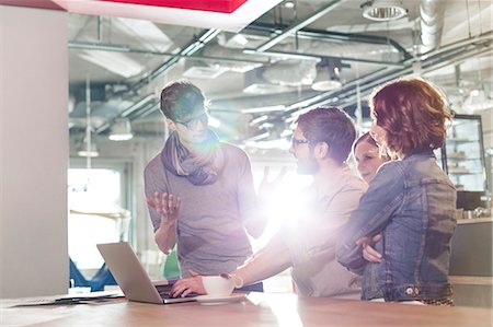 Creative business people meeting at laptop in sunny office Stock Photo - Premium Royalty-Free, Code: 6113-08087839