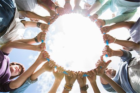 south asian teen - Team forming connected circle surrounding plastic hoop Stock Photo - Premium Royalty-Free, Code: 6113-08087958