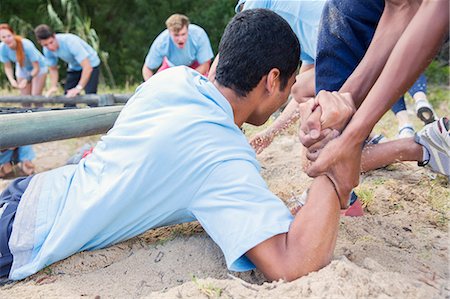 Teammate helping man on boot camp course Foto de stock - Sin royalties Premium, Código: 6113-08087904