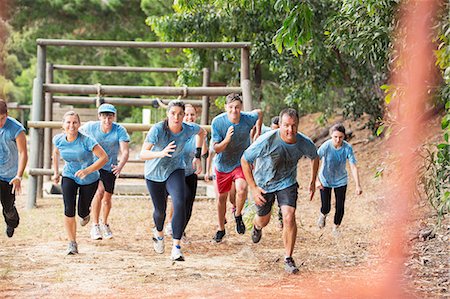 Team running on boot camp obstacle course Foto de stock - Sin royalties Premium, Código: 6113-08087926