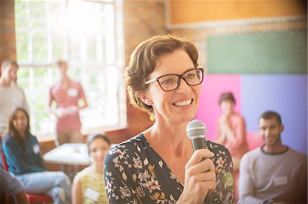 Audience behind smiling speaker with microphone at community center Stock Photo - Premium Royalty-Free, Code: 6113-08087935