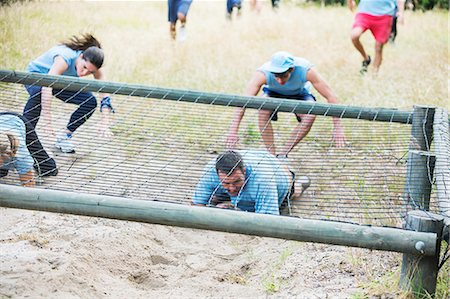 People crawling under net on boot camp obstacle course Stock Photo - Premium Royalty-Free, Code: 6113-08088041