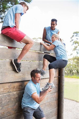 diversity team - Teammates helping woman over wall on boot camp obstacle course Stock Photo - Premium Royalty-Free, Code: 6113-08088042