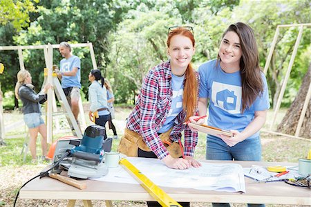 service construction - Portrait of smiling volunteers with digital tablet and blueprints at construction site Stock Photo - Premium Royalty-Free, Code: 6113-08088027