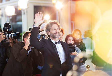 personas prominentes - Celebrity waving for paparazzi at event Foto de stock - Sin royalties Premium, Código: 6113-08088149