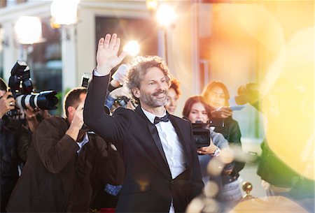 paparazzi camera flash at night - Celebrity waving for paparazzi at event Stock Photo - Premium Royalty-Free, Code: 6113-08088149