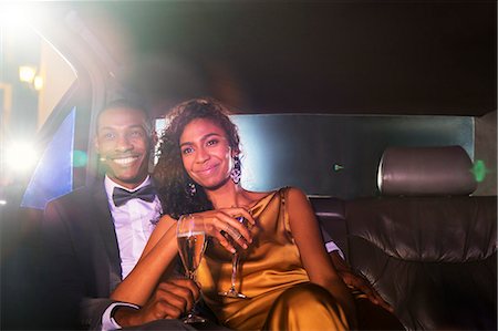 Smiling celebrity couple drinking champagne inside limousine outside event Photographie de stock - Premium Libres de Droits, Code: 6113-08088178