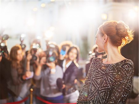 Celebrity turning and smiling at paparazzi photographers at event Stock Photo - Premium Royalty-Free, Code: 6113-08088182