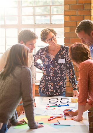 standing on a table - Creative business people reviewing proofs at table Stock Photo - Premium Royalty-Free, Code: 6113-08088117