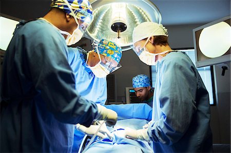 Surgeons performing surgery in operating room Foto de stock - Sin royalties Premium, Código: 6113-08088268