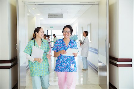 Smiling nurses talking in hospital corridor Foto de stock - Sin royalties Premium, Código: 6113-08088275