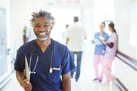 Portrait of smiling doctor in hospital corridor Stock Photo - Premium Royalty-Free, Code: 6113-08088281