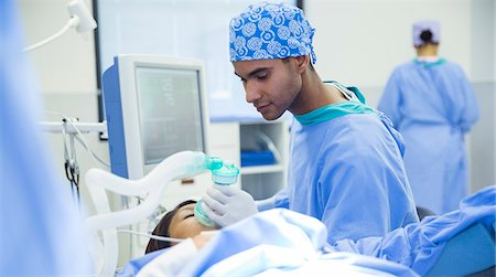 simsearch:6113-08088295,k - Anesthesiologist holding oxygen mask over patient's face in operating room Stockbilder - Premium RF Lizenzfrei, Bildnummer: 6113-08088288