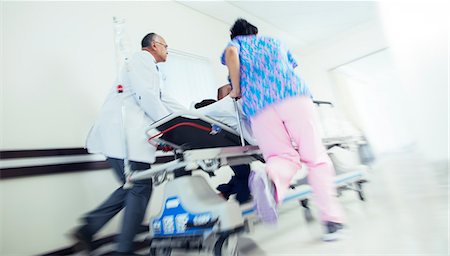 simsearch:6113-07589273,k - Doctor and nurse rushing patient on stretcher in hospital corridor Stock Photo - Premium Royalty-Free, Code: 6113-08088290