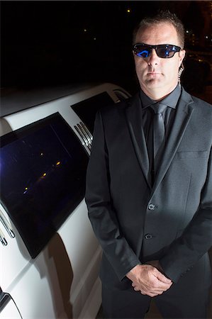 Portrait of serious bodyguard in sunglasses outside limousine at event Stock Photo - Premium Royalty-Free, Code: 6113-08088210