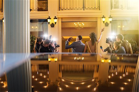 personas prominentes - Celebrity couple arriving and waving at paparazzi photographers at event Foto de stock - Sin royalties Premium, Código: 6113-08088211