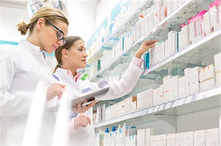 person reaching shelf - Pharmacists taking inventory in pharmacy Stock Photo - Premium Royalty-Free, Code: 6113-08088384