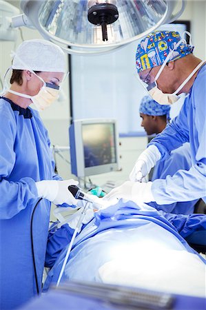 scrubs - Surgeons performing surgery in operating room Stock Photo - Premium Royalty-Free, Code: 6113-08088311
