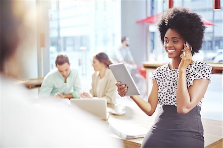 Businesswoman talking and cell phone and using digital tablet Stock Photo - Premium Royalty-Free, Code: 6113-08088473