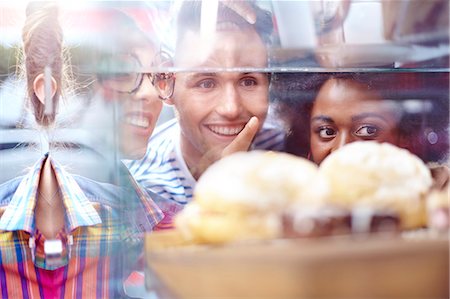 simsearch:6113-06753632,k - Friends pointing at desserts in display case at cafe Stock Photo - Premium Royalty-Free, Code: 6113-08088489