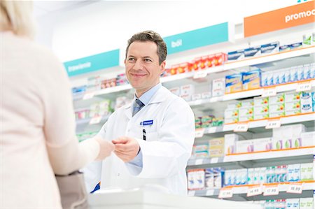 drugstore - Smiling pharmacist assisting customer in pharmacy Stock Photo - Premium Royalty-Free, Code: 6113-08088407