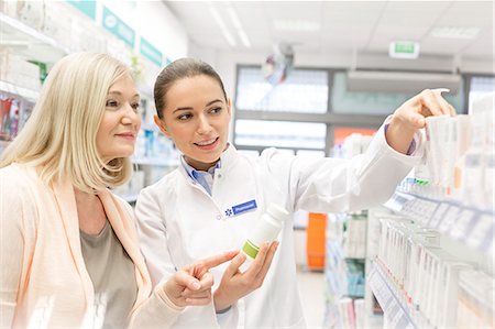 pharmacien (homme et femme) - Pharmacist recommending products to customer in pharmacy Photographie de stock - Premium Libres de Droits, Code: 6113-08088422