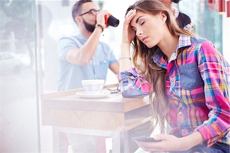 problem phone - Tired woman with head in hands at cafe Stock Photo - Premium Royalty-Free, Code: 6113-08088514