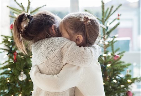 people christmas pictures - Girls hugging in front of Christmas trees Stock Photo - Premium Royalty-Free, Code: 6113-08088524