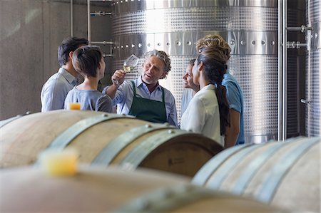 Vintner and winery employees examining wine in cellar Stock Photo - Premium Royalty-Free, Code: 6113-08171152