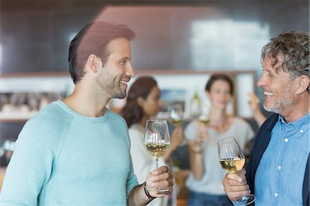 Friends wine tasting and talking in winery tasting room Stock Photo - Premium Royalty-Free, Code: 6113-08171172