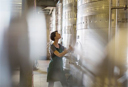 Vintner checking stainless steel vat in winery cellar Stock Photo - Premium Royalty-Free, Code: 6113-08171137