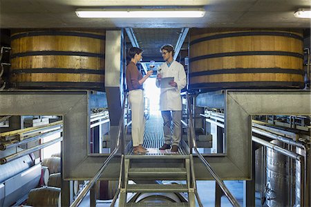 full body image of person in lab coat - Vintners examining wine on platform in winery cellar Stock Photo - Premium Royalty-Free, Code: 6113-08171136