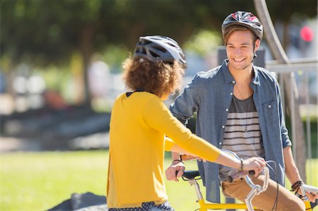 simsearch:6113-08171306,k - Man and woman with bicycles wearing helmets and talking in park Fotografie stock - Premium Royalty-Free, Codice: 6113-08171266