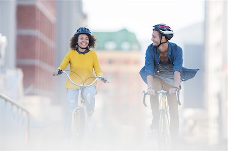 Young couple riding bicycles in city Stock Photo - Premium Royalty-Free, Code: 6113-08171284