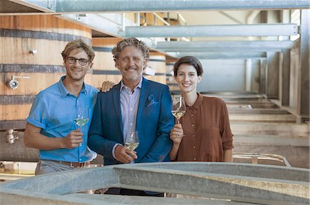 Portrait smiling vintners with white wine in winery cellar Stock Photo - Premium Royalty-Free, Code: 6113-08171200