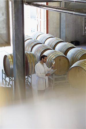 simsearch:649-07437501,k - Vintner in lab coat examining white wine in winery cellar Stock Photo - Premium Royalty-Free, Code: 6113-08171207