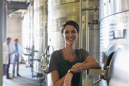 Portrait smiling vintner at stainless steel vat in winery cellar Photographie de stock - Premium Libres de Droits, Code: 6113-08171216