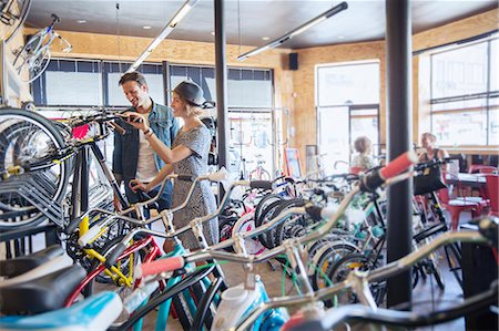simsearch:6113-07542414,k - Couple browsing bicycles on rack in bicycle shop Photographie de stock - Premium Libres de Droits, Code: 6113-08171352