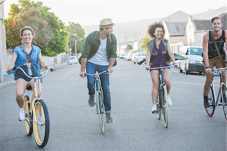 simsearch:6113-08171264,k - Friends riding bicycles in a row on street Stock Photo - Premium Royalty-Free, Code: 6113-08171364