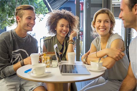 Friends hanging out with laptop and coffee on cafe patio Stock Photo - Premium Royalty-Free, Code: 6113-08171316