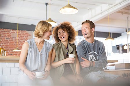 simsearch:6113-06908578,k - Laughing friends drinking coffee in cafe Stock Photo - Premium Royalty-Free, Code: 6113-08171318