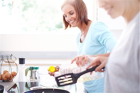 pan on stove - Smiling women cooking in kitchen Stock Photo - Premium Royalty-Free, Code: 6113-08171487