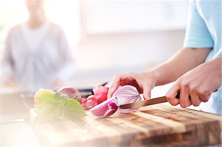 Woman slicing red onion on cutting board in kitchen Foto de stock - Sin royalties Premium, Código: 6113-08171516