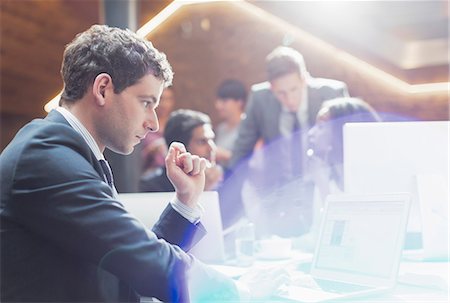 Serious businessman working at laptop in office Stock Photo - Premium Royalty-Free, Code: 6113-08184273