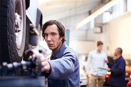 Mechanic reaching for part in auto repair shop Stock Photo - Premium Royalty-Free, Code: 6113-08184353