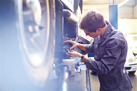 simsearch:6113-08184381,k - Mechanic examining part in auto repair shop Stock Photo - Premium Royalty-Free, Code: 6113-08184351