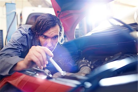 simsearch:6113-08184367,k - Mechanic working on engine in auto repair shop Photographie de stock - Premium Libres de Droits, Code: 6113-08184357