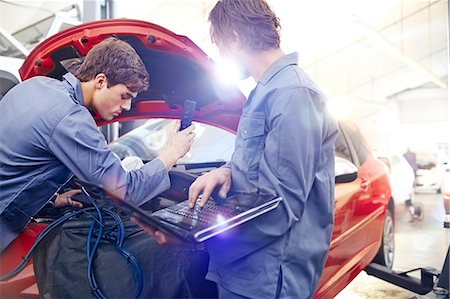 Mechanics with laptop working on car engine in auto repair shop Photographie de stock - Premium Libres de Droits, Code: 6113-08184354