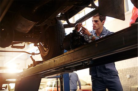 Mechanic working under car in auto repair shop Stock Photo - Premium Royalty-Free, Code: 6113-08184359