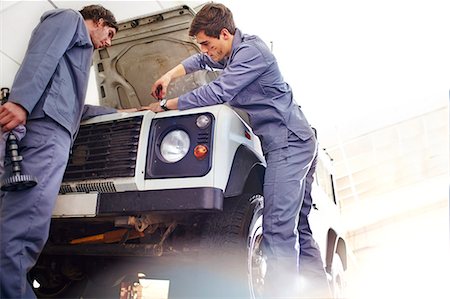 simsearch:6113-08184367,k - Mechanics working on engine in auto repair shop Photographie de stock - Premium Libres de Droits, Code: 6113-08184360